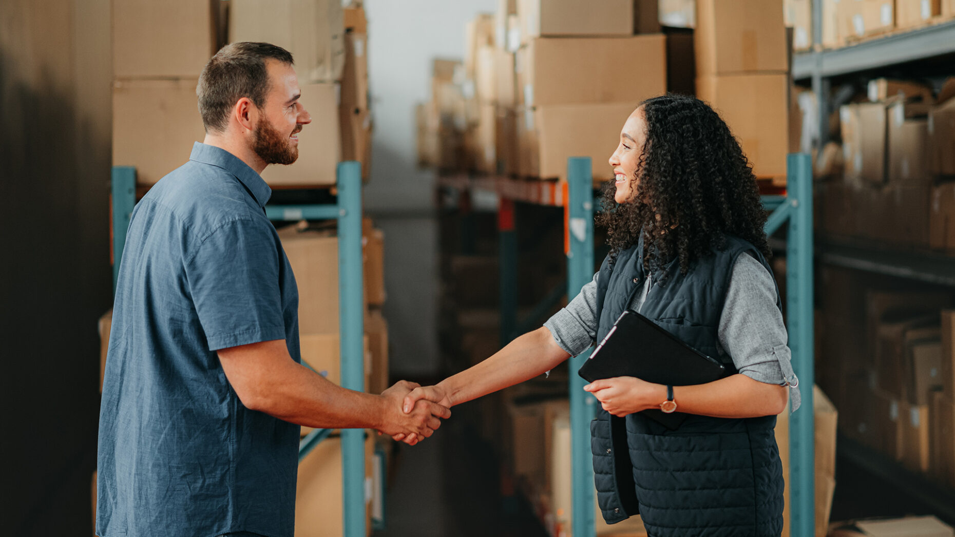Shipping, supply chain and delivery partner with handshake for partnership, support and thank you in a warehouse. Box logistics or stock factory employee with teamwork, collaboration business meeting
