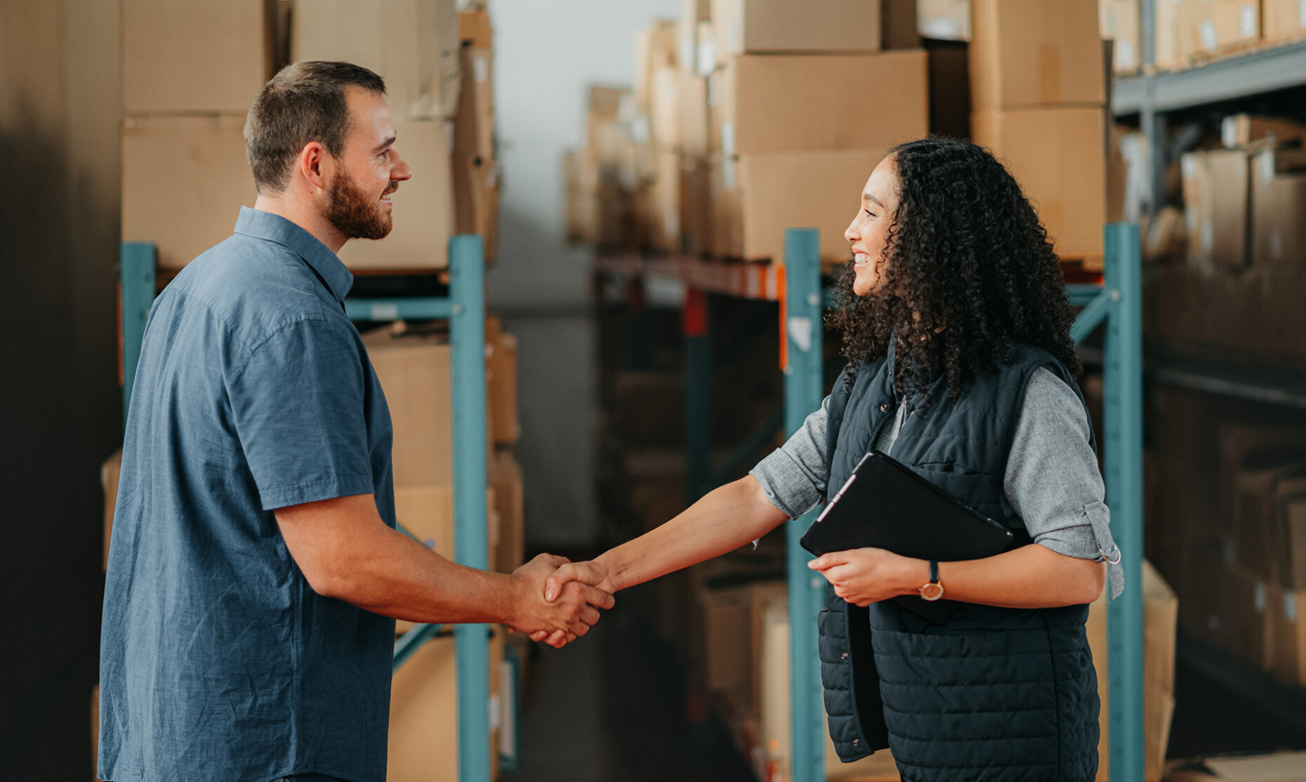Shipping, supply chain and delivery partner with handshake for partnership, support and thank you in a warehouse. Box logistics or stock factory employee with teamwork, collaboration business meeting