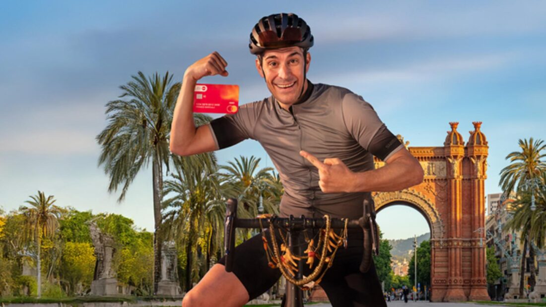 Mann auf Fahrrad mit Debit Mastercard in der Hand