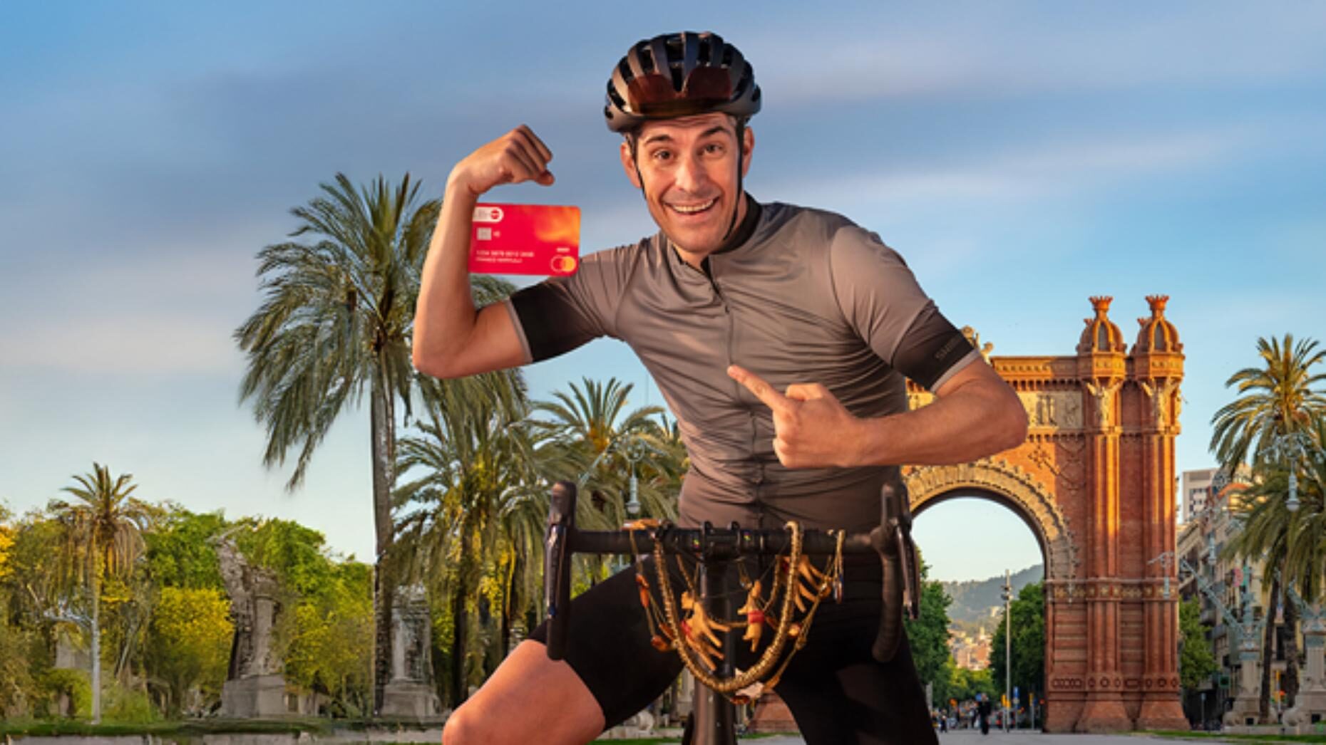 Mann auf Fahrrad mit Debit Mastercard in der Hand